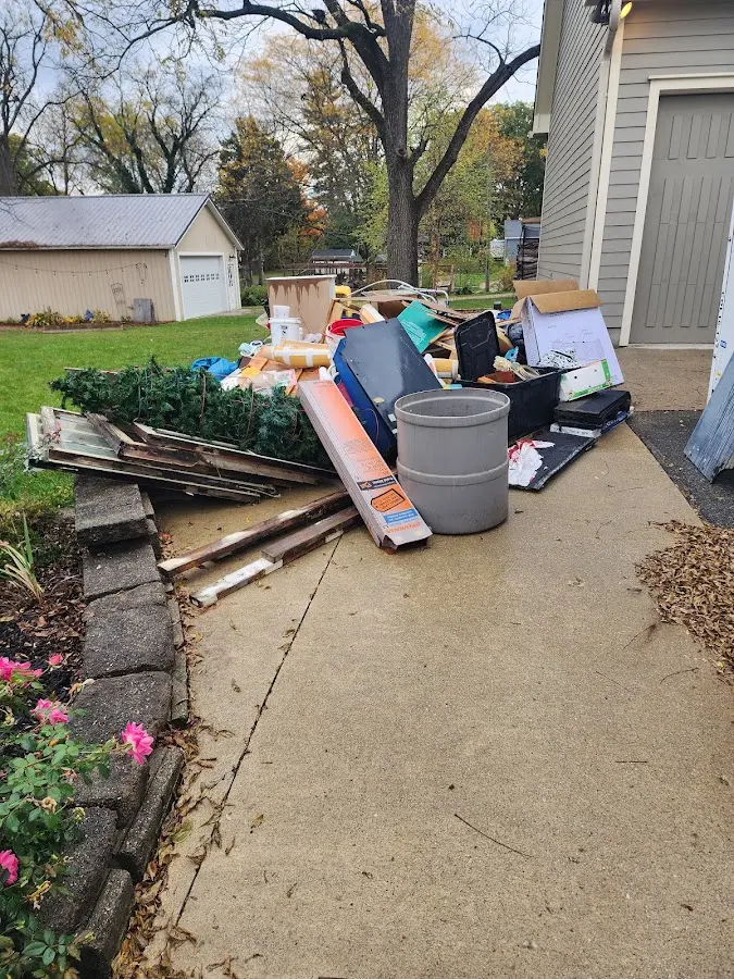 Dumpster being loaded with debris for Estate Cleanout Dumpster Rental in Pensacola
